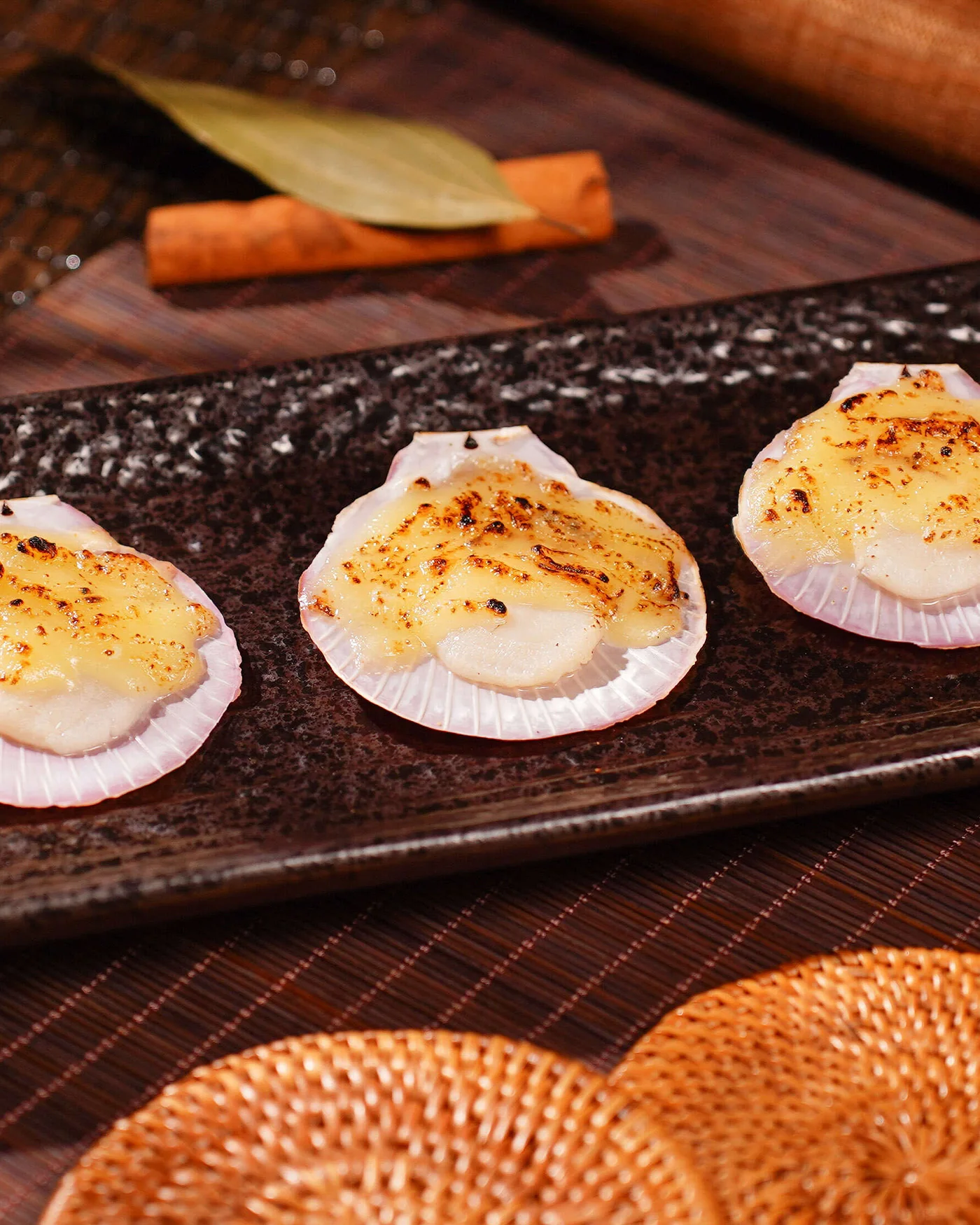 Cheese-baked pink scallops on a slate tray