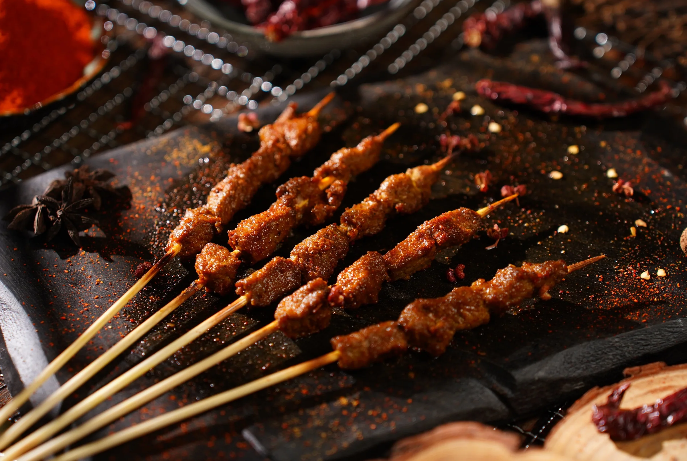 Spice-dusted meat skewers on a slate